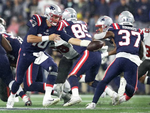 Running back breaking through the line